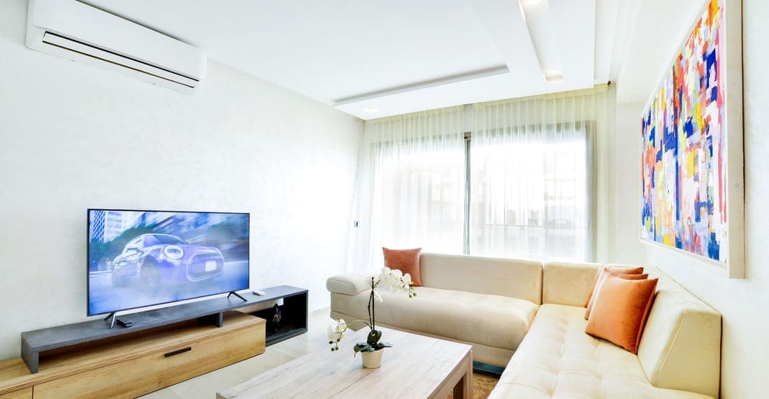 Salon cosy avec canapé et grande baie vitrée, aperçu d'un logement loué en courte durée